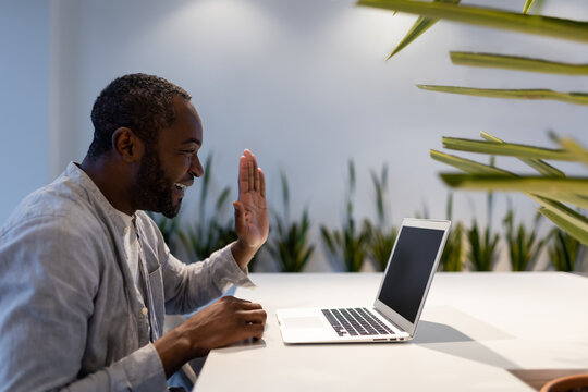 African American businessman participating in video call, discussing project performance in office