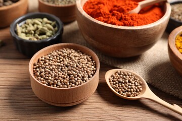 Different aromatic spices on wooden table, closeup
