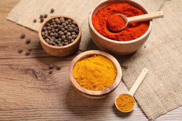 Different aromatic spices on wooden table, closeup