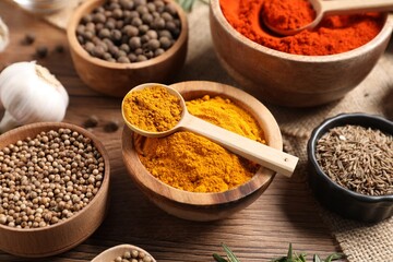 Different aromatic spices on wooden table, closeup