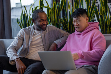 Multiethnic business partners collaborating on laptop in informal workspace