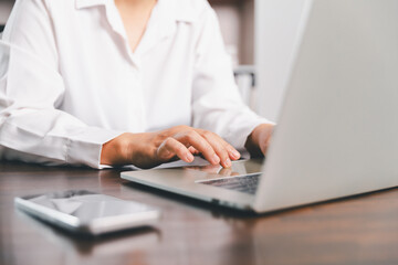 Businesswoman manages finances by using banking and accounting system to calculate costs, taxes,...