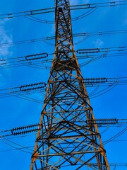 This transmission tower stands tall against a backdrop of blue skies and fluffy clouds, showcasing the vital infrastructure that keeps our communities powered. 