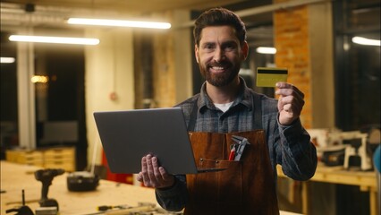 Happy Caucasian employer male repairman guy hold laptop carpenter use credit card remote shopping...