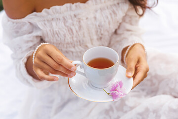 Closeup of Elegant Woman Holding Tea Cup in White Romantic Dress