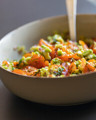 close up stock photo of fresh homemade guacamole in a bowl, perfect for summer, healthy snacking, and refreshing party appetizers