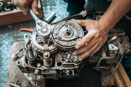 Motorcycle Engine Rebuild,  Mechanic use Socket Wrench Handle repairing Engine ,working at garage,  motorcycle repair concept