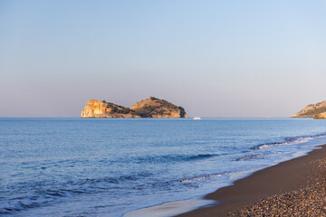 A serene sandy beach overlooks calm turquoise sea waters. Sarigerme, Turkey