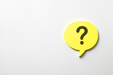 FAQ and customer support concept. A yellow speech bubble sticky note with a question mark on a white background.For social media comments, messaging apps,answering frequently asked questions.