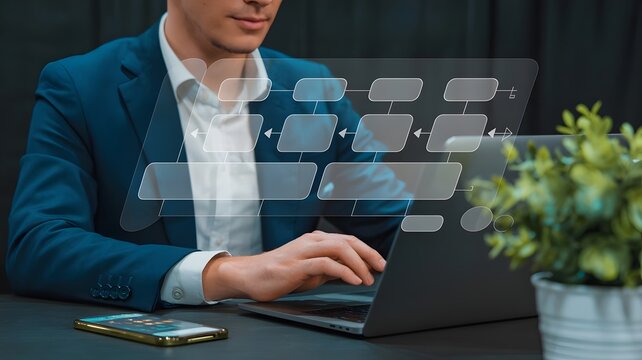 Business professional using a laptop to create a virtual flowchart, demonstrating digital technology for process organization and optimization.