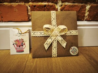 chocolate cake on wooden background, gift packaging design lace ribbon on a gift