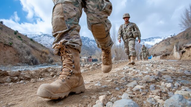 Soldiers marching on a rocky path during a mountainous training exercise