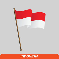 the Indonesian national flag flies on a brown wooden pole