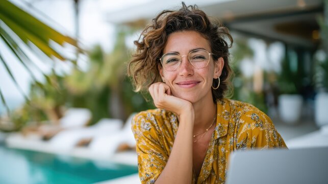 Smiling woman enjoying a sunny day by the poolside while working