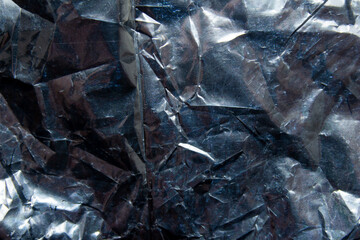 Crumpled reflective shiny gift wrapping material texture background