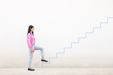 Young woman in pink shirt smiling and climbing illustrated stairs on a white wall