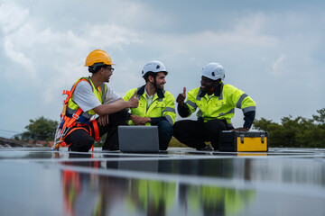 Solar technicians in protective helmets and vests collaborate on rooftop during installation...