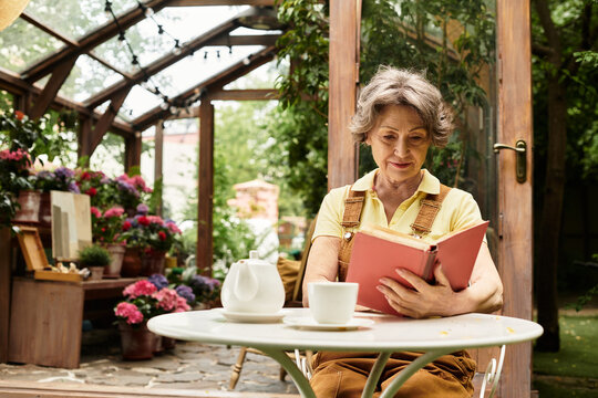 Senior woman enjoying a peaceful moment reading in a vibrant garden setting - Powered by Adobe