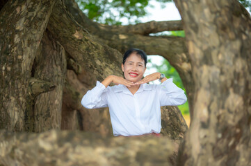 Asian women in traditional poses.Laos girl in traditional dress against a backdrop of trees.