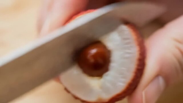 Cutting a Fresh Lychee Fruit with a Knife.