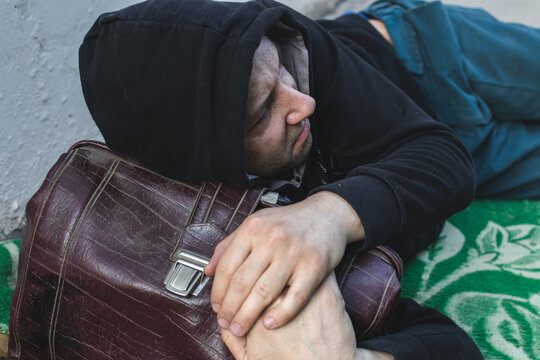 A homeless marginal in dirty clothes living on the street
