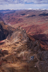 Majestic mountain landscape with winding paths under a partly cloudy sky in Tibet, China