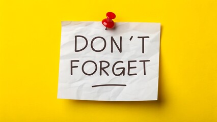 Reminder note with don't forget text pinned on yellow background for important message

