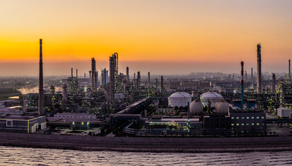 Large oil refinery and chemical plant with industrial equipment at sunset