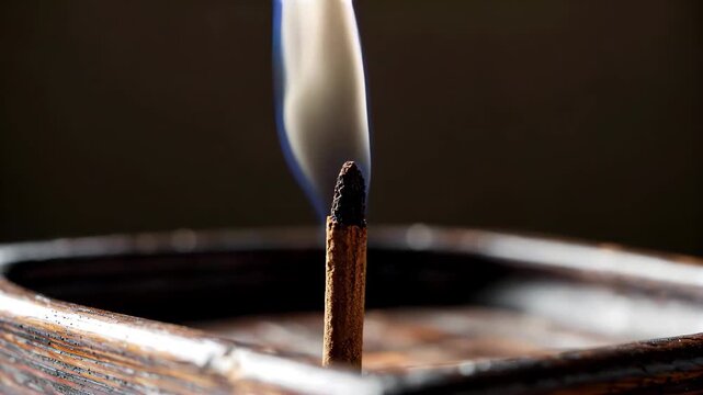 Close-up of a match in flames Zen scent curls up smoke