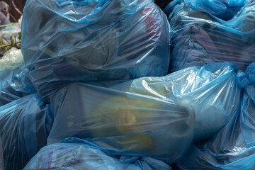 A close-up photo of trash in blue trash bags