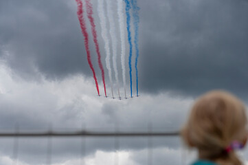 Paris, France - 07 14 2025: Air show of July 14. Alphajet of the patrol of France flying above the district of La Defense