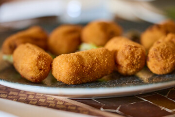 Fried ham croquettes served on a restaurant plate. Traditional Spanish tapas dish