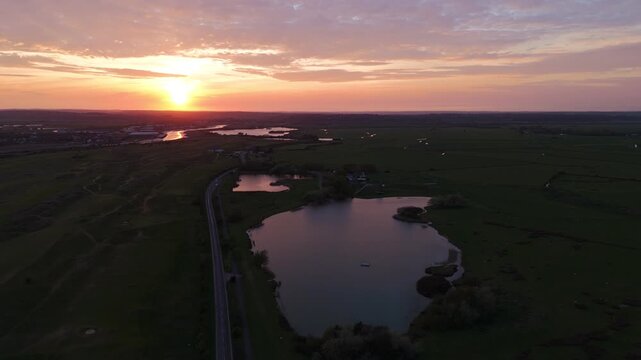 Drone shot of water estuary and beach at sunset in Camber Sands, England