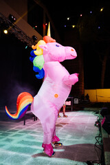 Colorful Unicorn Mascot Celebrating During a Vibrant LGBTQ Pride Event at a Lively Venue