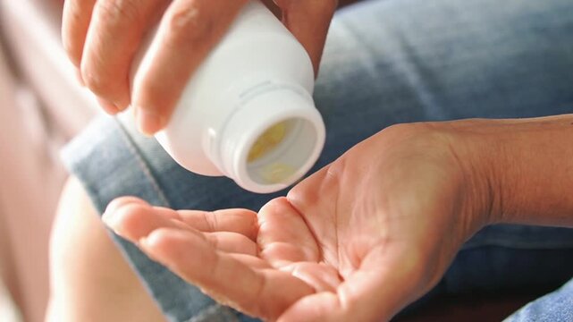Close up hand holding bottle oil collagen for weight loss, wellness health, antioxidant. Healthy lifestyle people nutrition anti aging. Food supplements medicine for healthcare. Senior woman home care
