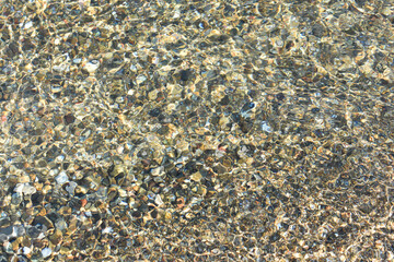 Stones and sand under water. Natural background. Stone texture. Abstract background with pebbles. Spiaggia di Settefrati: beach near Cefalu, Sicily. Summer and holidays. Summer beach in Italy.