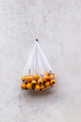 Plastic bags of loquats hanging on the wall