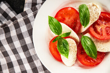 Caprese salad mozzarella and tomato, basil fresh delicious gourmet food background on the table rustic food top view copy space keto and paleo diet vegan and vegan food
