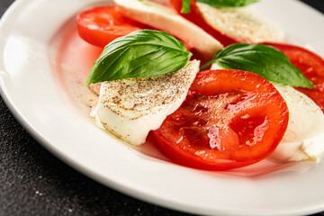 Caprese salad mozzarella and tomato, basil fresh delicious gourmet food background on the table rustic food top view copy space keto and paleo diet vegan and vegan food