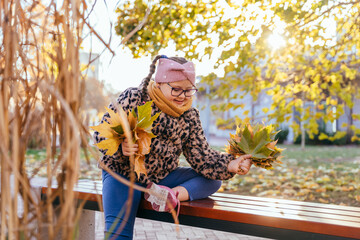 Mother hugging daughter with special needs in autumn park