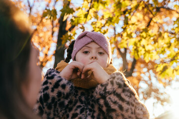 Cheerful girl with Down syndrome showing heart sign outdoors