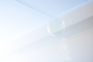 A soap bubble floats gracefully in the air against a blue sky