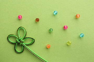 クローバーの水引飾りとビーズを使った背景素材　背景色黄緑色