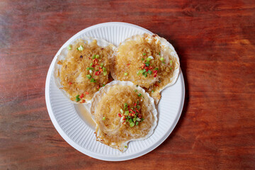 Garlic-flavored vermicelli scallops in a white paper plate