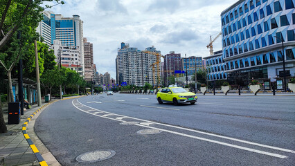 The beautiful yellow car on the road at the big city.