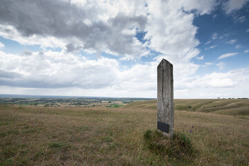 A peaceful rural scene showing a hillside path under a cloudy sky, with open views across the countryside.