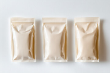 Three versatile packaging pouches varying in size are displayed on a pristine white background. Their unbranded, flexible design offers a modern touch perfect for product mockups.