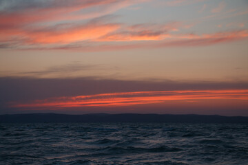 waves on a lake and red twilight sky after sunset