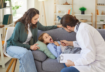 Friendly male pediatrician in medical coat checking little boy throat, tonsils, specialist exams...