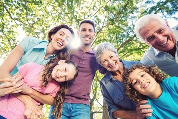 Low angle view of happy caucasian multi-generation family looking at camera while enjoying in park